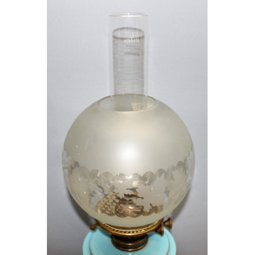 261 - Antique oil lamp with cornflour blue glass reservoir and cast metal base, approx 64cm H