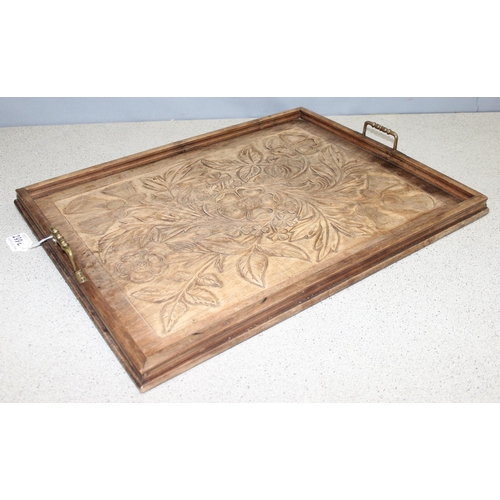 299C - An early 20th century Arts & Crafts period carved mahogany serving tray decorated with floral motifs... 