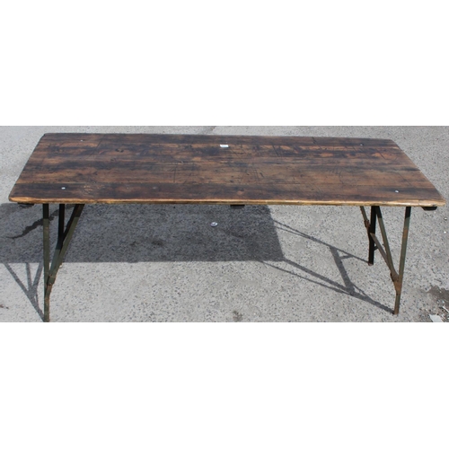 100 - A vintage wooden topped folding trestle table with metal base likely c.1930, approx 181cm wide x 68c... 