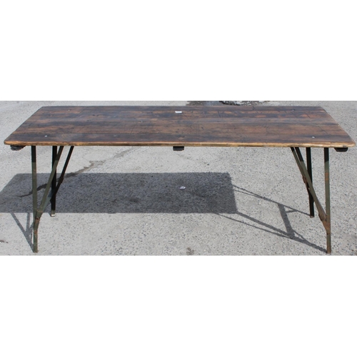 100 - A vintage wooden topped folding trestle table with metal base likely c.1930, approx 181cm wide x 68c... 