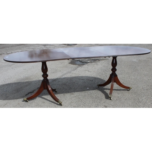 121 - An antique style mahogany twin pedestal dining table, approx 244cm wide x 103cm deep x 77cm tall