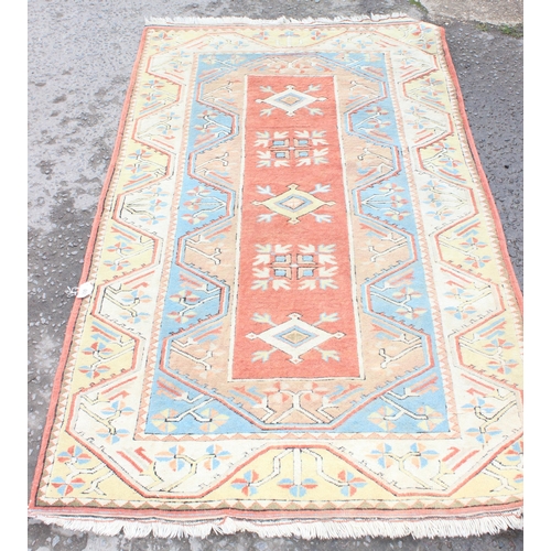 200 - A vintage yellow, orange and blue ground rug, approx 120 cm x 220cm