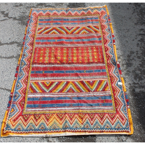 219 - An unusual vintage colourful handmade flatweave rug of yellow, red and blue ground, the rug containi... 