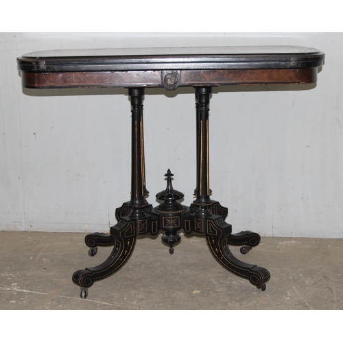 5 - A Victorian burr walnut and ebonised card or games table standing on pillar supports with blue baize... 