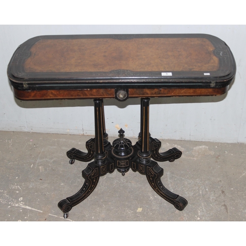 5 - A Victorian burr walnut and ebonised card or games table standing on pillar supports with blue baize... 