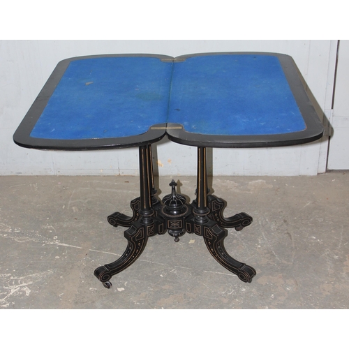 5 - A Victorian burr walnut and ebonised card or games table standing on pillar supports with blue baize... 