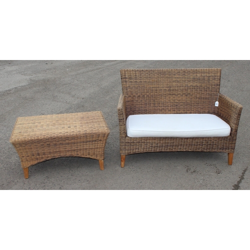 26 - A wicker conservatory 2 seater sofa and a small matching table, sofa approx 120cm wide