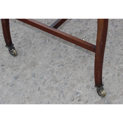 28 - A vintage glazed mahogany bijouterie table with thin legs and castors, approx 66cm wide x 47cm deep ... 