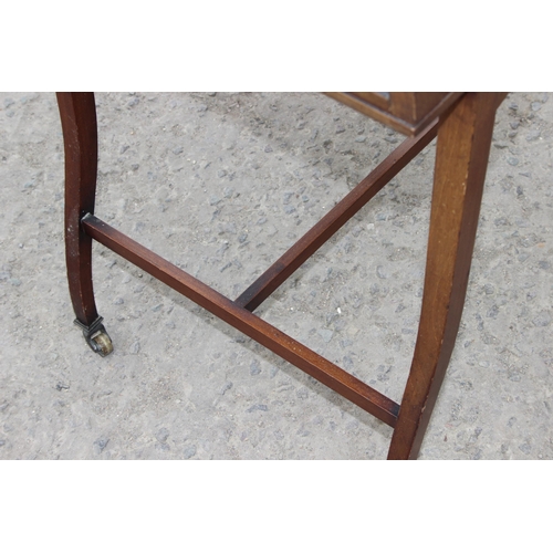 28 - A vintage glazed mahogany bijouterie table with thin legs and castors, approx 66cm wide x 47cm deep ... 