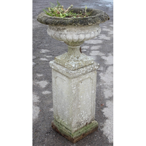 300 - A large weathered planted reconstituted stone urn on plinth, approx 56cm wide x 56cm deep x 114cm ta... 