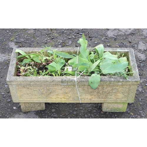 305 - A reconstituted stone garden trough planter with feet and moulded oak leaf decoration, with plants, ... 