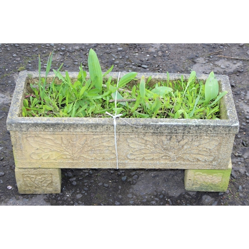 306 - A reconstituted stone garden trough planter with feet and moulded oak leaf decoration, with plants, ... 