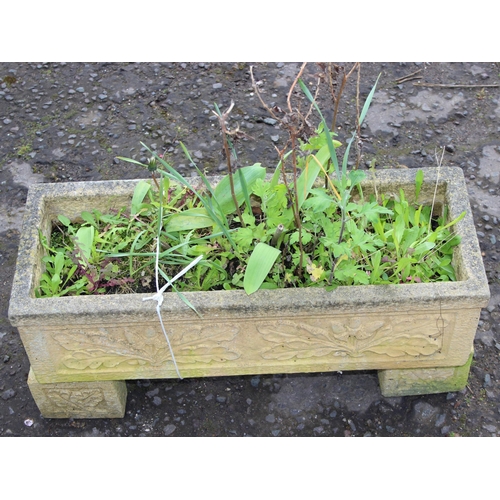 307 - A reconstituted stone garden trough planter with feet and moulded oak leaf decoration, with plants, ... 