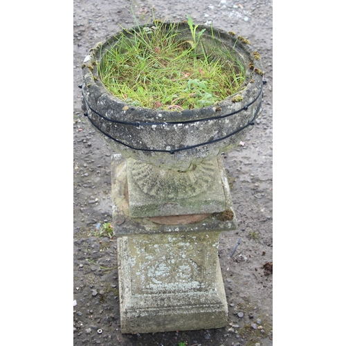 303 - A large weathered reconstituted stone urn on plinth A/F, approx 42cm wide x 42cm deep x 84cm tall