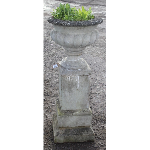 302 - A large weathered reconstituted stone urn on plinth, approx 42cm wide x 42cm deep x 110cm tall