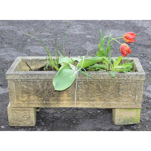 309 - A reconstituted stone garden trough planter with feet and moulded oak leaf decoration, with plants, ... 