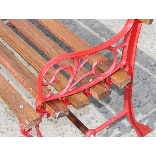 312 - Wooden slatted garden bench with red painted cast iron ends, approx 105cm wide x 48cm deep x 73cm ta... 