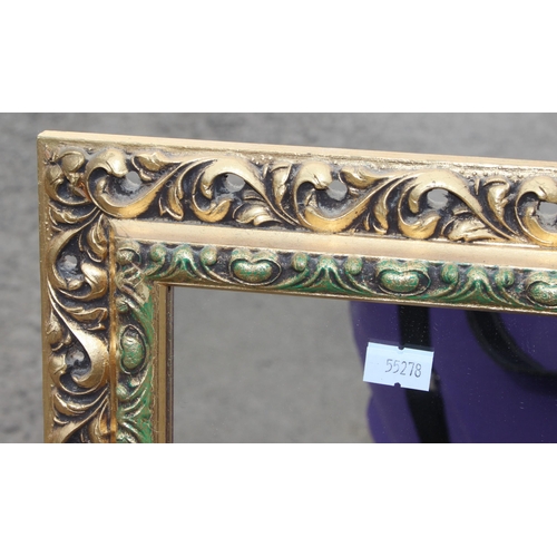 419 - A gilt framed wall mirror with highly decorative frame, approx 130cm x 38cm