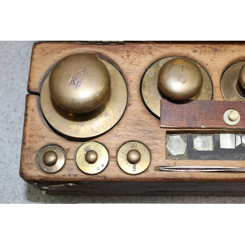 652 - Vintage set of brass and other balance scale weights, set in heavy wooden box, weights ranging from ... 