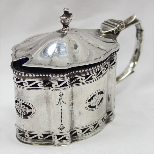 1061 - An early 20th century silver mustard pot of Georgian form with engraved and pierced decoration and b... 