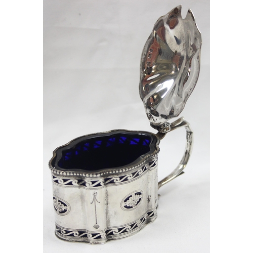 1061 - An early 20th century silver mustard pot of Georgian form with engraved and pierced decoration and b... 