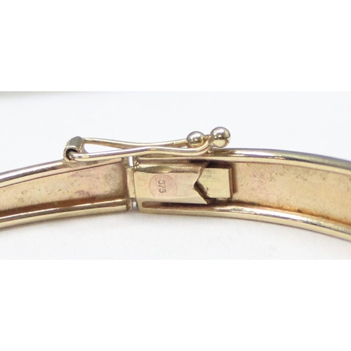 1116 - A retro 9ct gold cuff bangle with engraved decoration, marked 375 and XRF confirmed, approx 5.57g gr... 