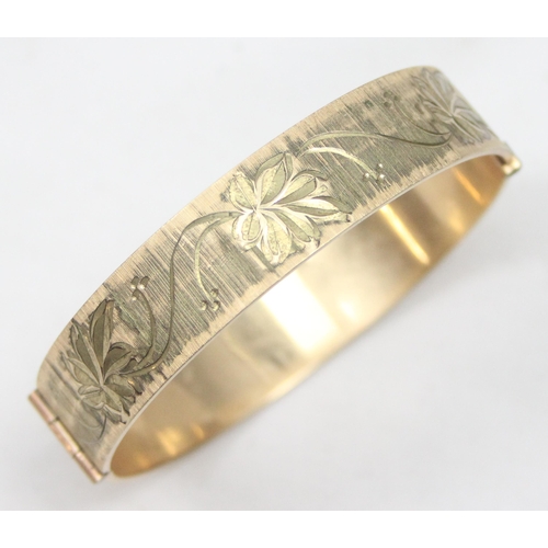 1139 - A retro 9ct rolled gold 50 micron bangle with engraved decoration, approx 59mm x 55mm interior measu... 