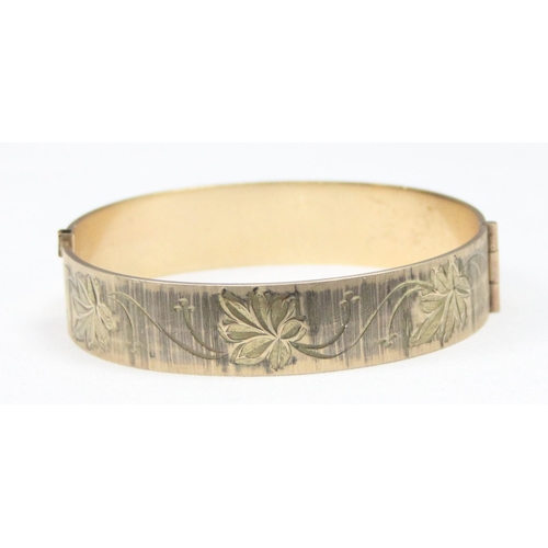 1139 - A retro 9ct rolled gold 50 micron bangle with engraved decoration, approx 59mm x 55mm interior measu... 