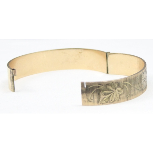 1139 - A retro 9ct rolled gold 50 micron bangle with engraved decoration, approx 59mm x 55mm interior measu... 