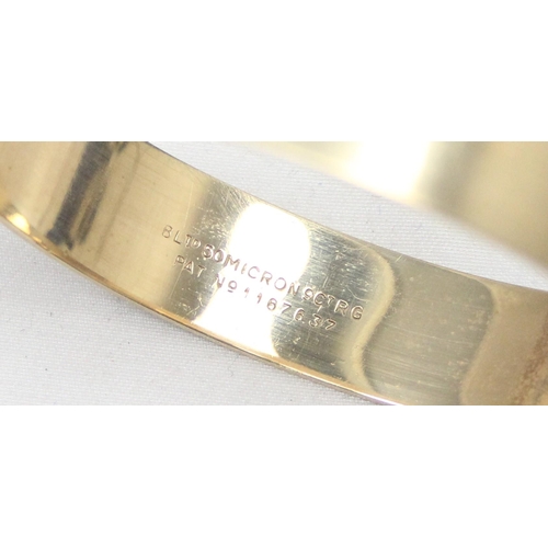 1139 - A retro 9ct rolled gold 50 micron bangle with engraved decoration, approx 59mm x 55mm interior measu... 