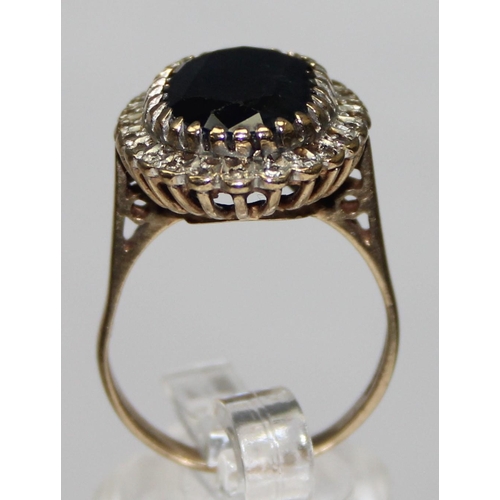 1178 - A large 9ct gold sapphire and diamond cocktail ring, a large central dark blue sapphire surrounded b... 