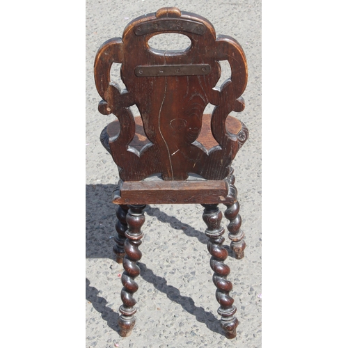 157 - An antique carved oak hall chair with barleytwist legs, approx 85cm tall