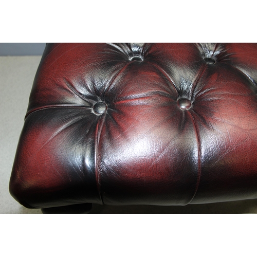 112 - Ox blood Chesterfield style footstool on wooden legs, approx 57 W x 57 D x 32cm H