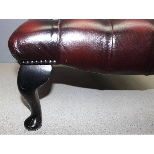 112 - Ox blood Chesterfield style footstool on wooden legs, approx 57 W x 57 D x 32cm H