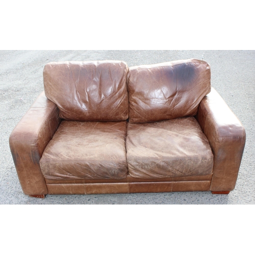 132 - A modern light brown 2 seater leather sofa, approx 173cm wide x 100cm deep x 84cm tall