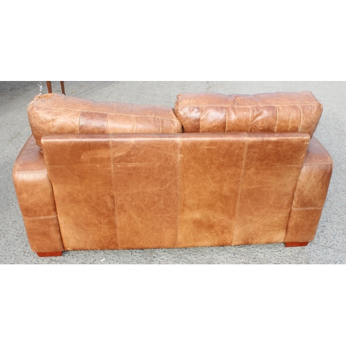 132 - A modern light brown 2 seater leather sofa, approx 173cm wide x 100cm deep x 84cm tall