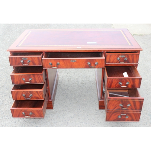 138 - A large antique style mahogany pedestal desk with red leather inset top, approx 137cm wide x 76cm de... 