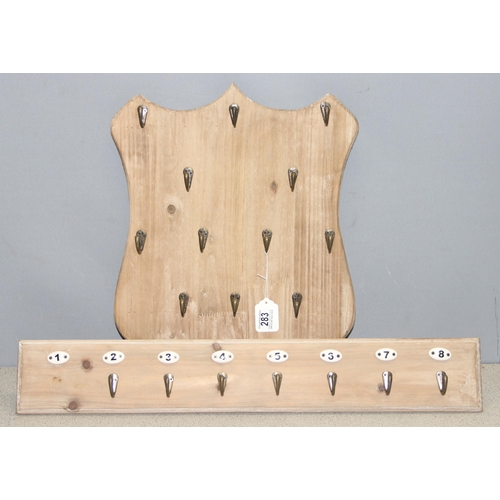 283 - 2 sets of coat hooks on wooden backs, one in the shape of a shield (largest approx 50cm x 4cm)