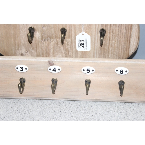 283 - 2 sets of coat hooks on wooden backs, one in the shape of a shield (largest approx 50cm x 4cm)