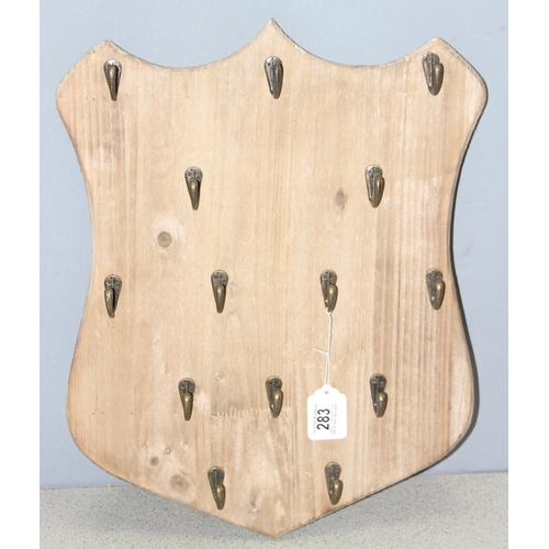 283 - 2 sets of coat hooks on wooden backs, one in the shape of a shield (largest approx 50cm x 4cm)