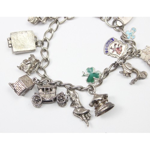 1189 - A good quality vintage silver charm bracelet with a large qty of silver charms to inc a Scooter & Ca... 