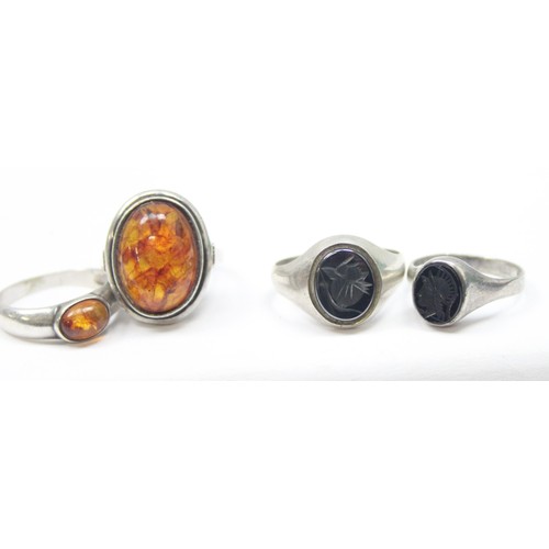 1192 - 4 assorted silver dress rings, 2 set with amber, the other 2 set with intaglio carvings, all XRF con... 