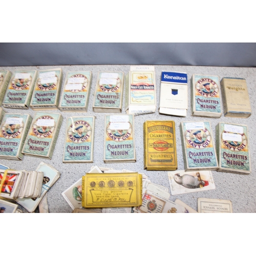 576 - A large qty of assorted cigarette cards, some in vintage Player's Cigarette and other packaging