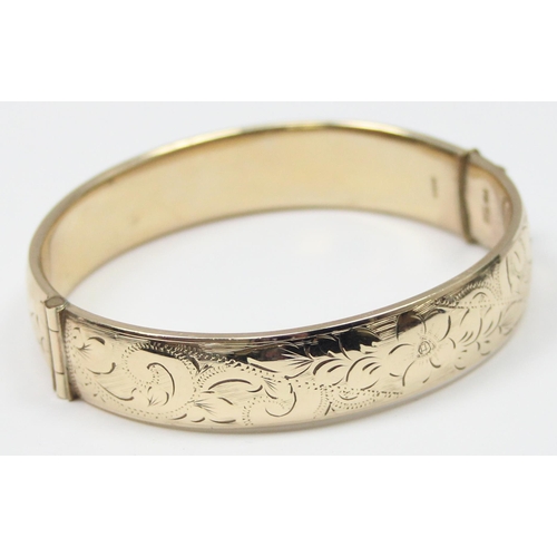 1195 - A retro 9ct gold on metal core bangle with engraved decoration, with patent 897224 safety clasp, app... 