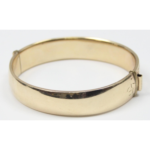 1195 - A retro 9ct gold on metal core bangle with engraved decoration, with patent 897224 safety clasp, app... 