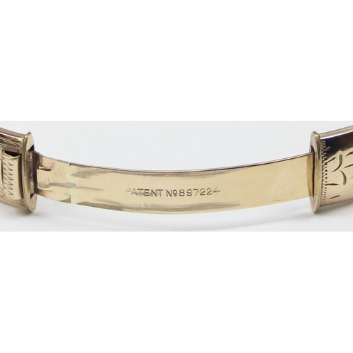 1195 - A retro 9ct gold on metal core bangle with engraved decoration, with patent 897224 safety clasp, app... 