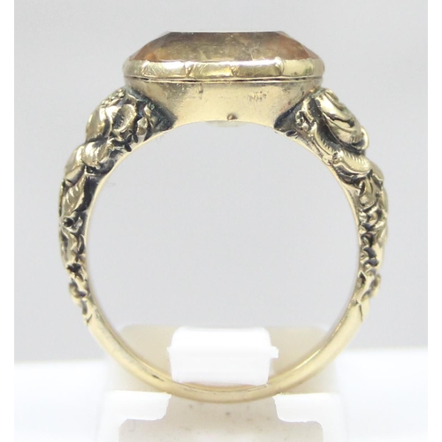 1197 - An unusual antique 15ct gold ring set with a facet cut citrine and floral engraved shoulders, unmark... 