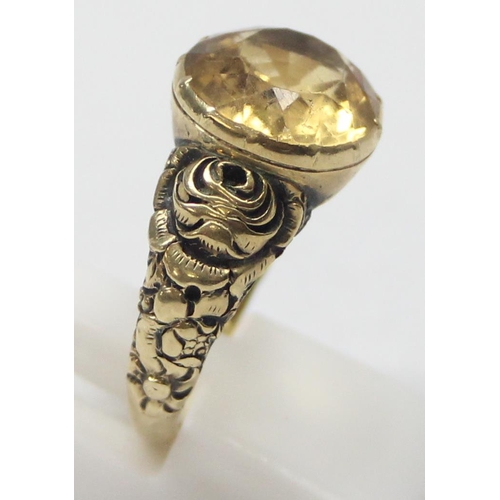 1197 - An unusual antique 15ct gold ring set with a facet cut citrine and floral engraved shoulders, unmark... 