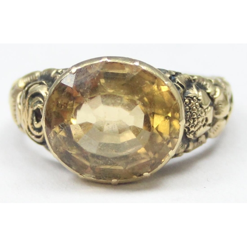 1197 - An unusual antique 15ct gold ring set with a facet cut citrine and floral engraved shoulders, unmark... 