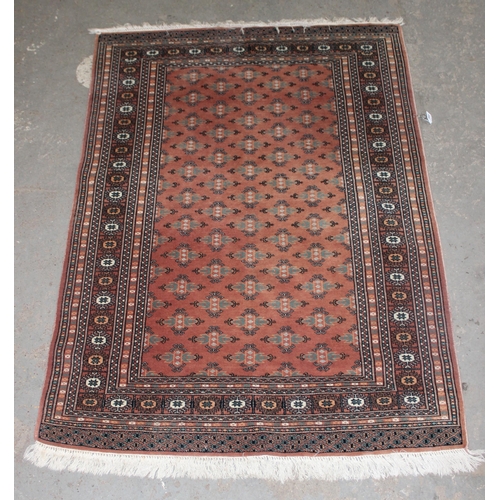 200 - A vintage Bokhara style rug of salmon ground, approx 180cm x 131cm